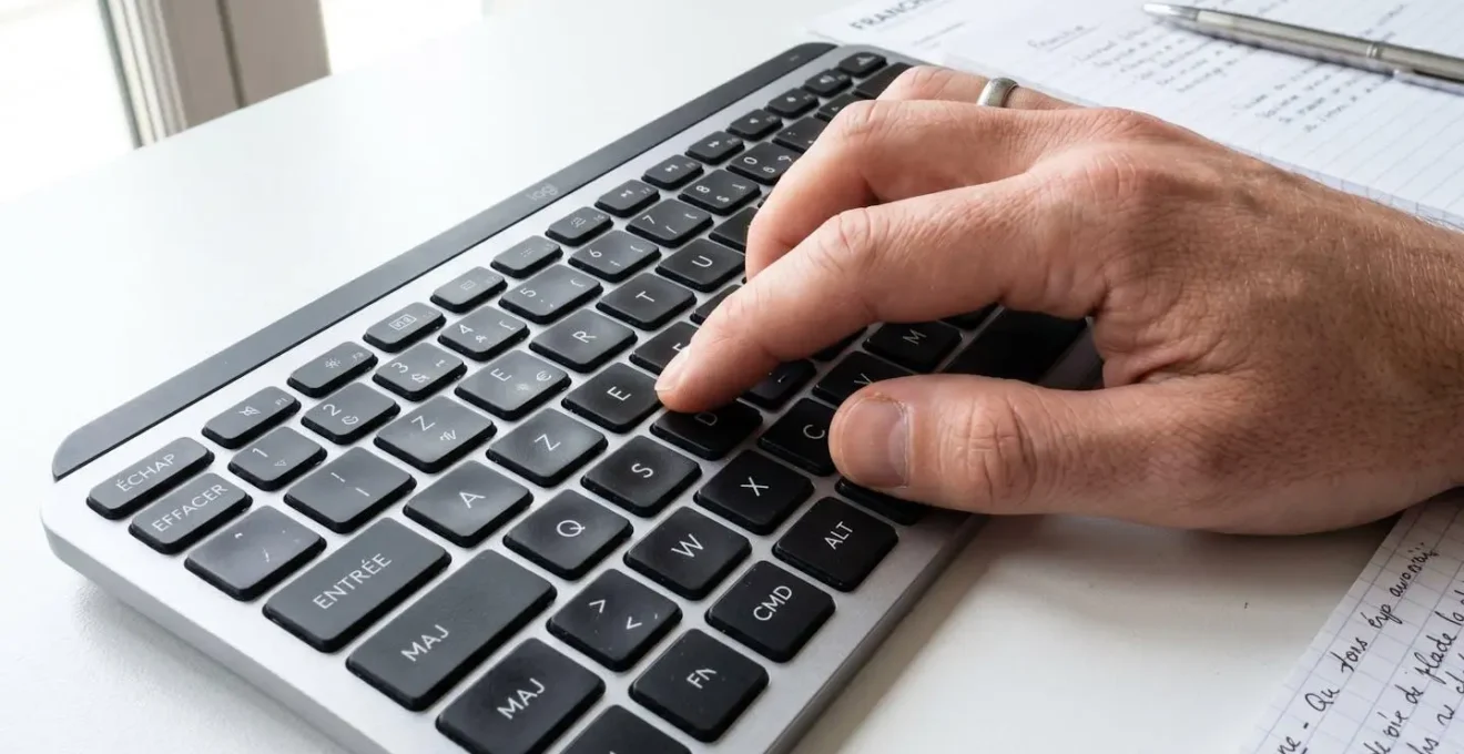 Macro photographie d'une main tapant sur un clavier d'ordinateur moderne avec mise au point sélective